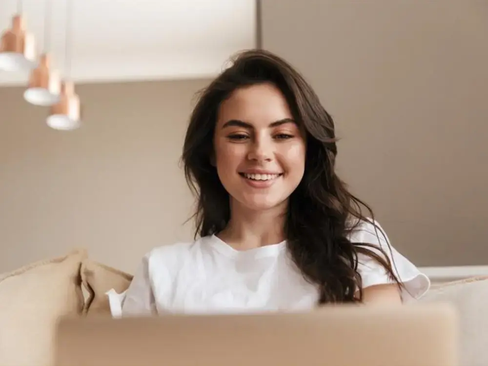 Beautiful young brunette woman relaxing on a couch at home